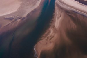 An abstract aerial photograph of where the land meets the sea