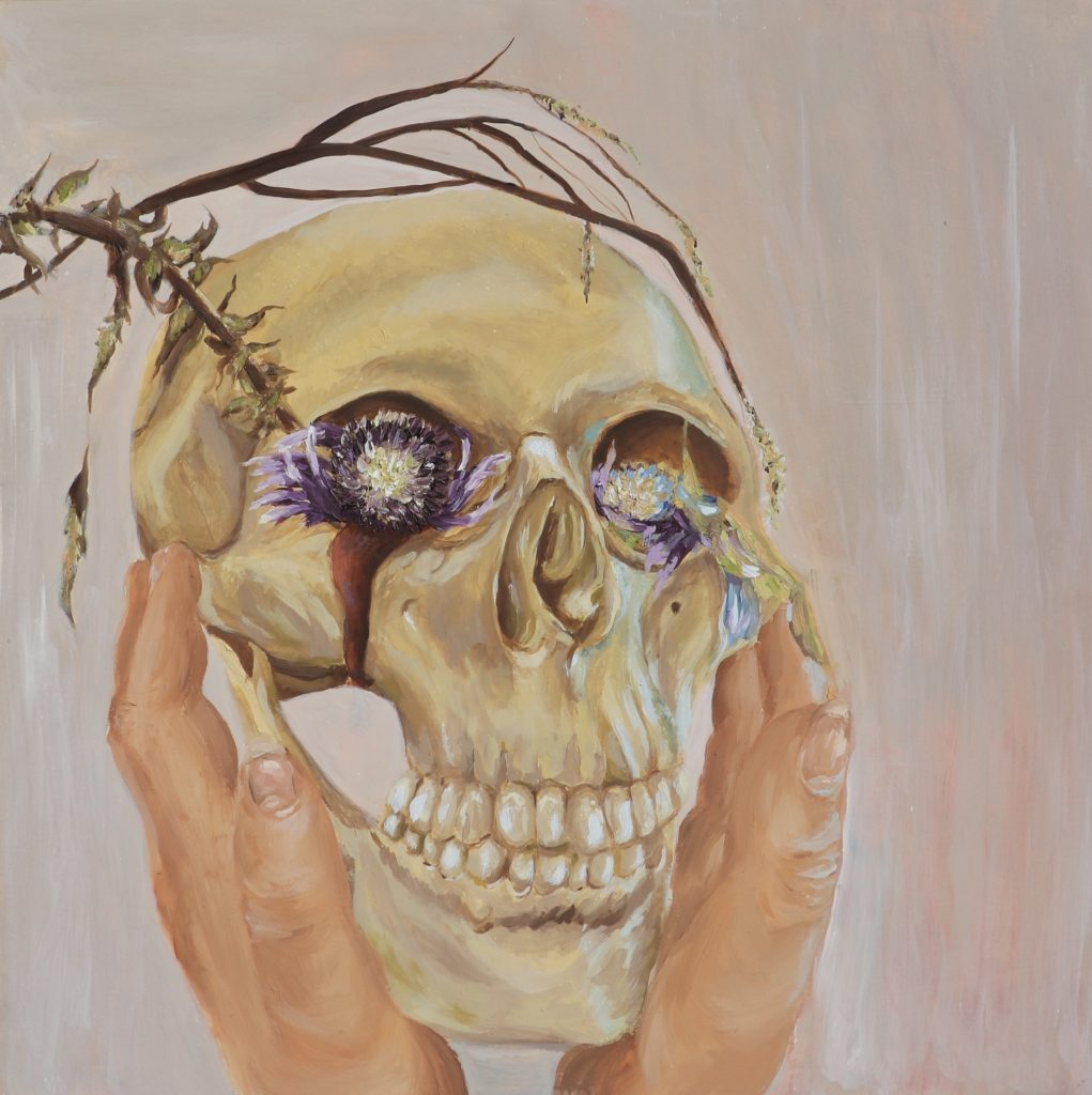 A painting of a pair of hands holding a skull, in the skull's eye sockets are purple flowers which are loosing their petals. 