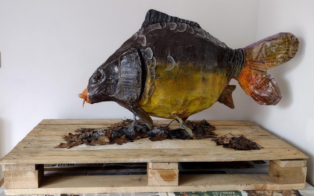 A realistic sculpture of large fish (a carp)