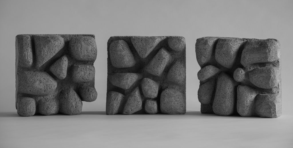 Three contemporary square sculptures made from breeze blocks. Each carved with a rounded texture. 